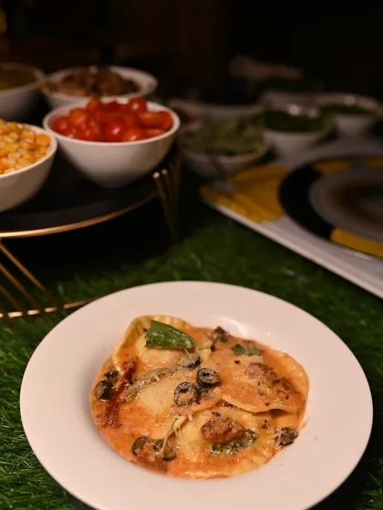 A finished plate of ravioli from our live station, showcasing the beautiful combination of pasta, sauce, and fresh garnishes.