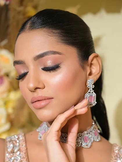 The details of this makeup look are designed to celebrate her beautiful features. The winged liner elongates the eye, and the soft pink tones on the lips and cheeks add a touch of warmth.