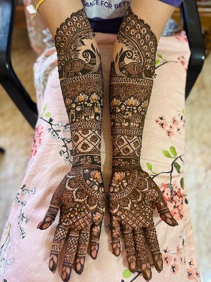 This full-arm design is packed with traditional elements, including rows of elephants, blooming lotuses, and majestic peacocks, all framed by intricate borders.