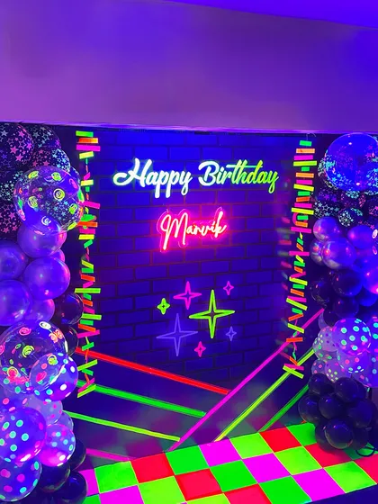 Another angle of the vibrant neon party photobooth. The combination of polka-dotted UV balloons and a glowing neon sign creates a high-energy atmosphere perfect for photos and dancing.