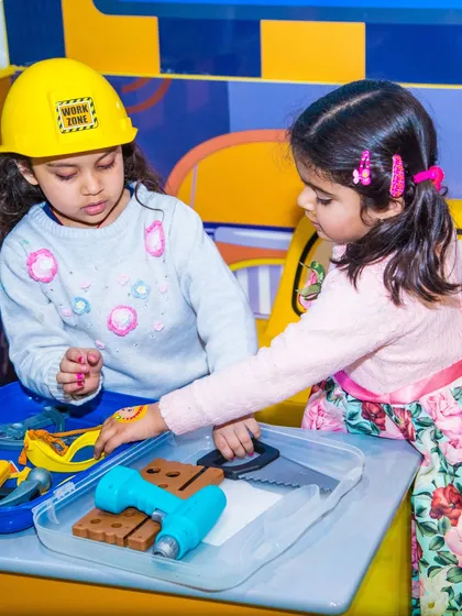 Two girls role-playing as construction workers with our toy tool set. This imaginative play station is a big hit in My Burrow.