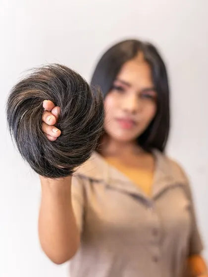 A model holding our Donut Bun extension. It's lightweight and customizable, allowing you to create a variety of bun hairstyles for any occasion, day or night.