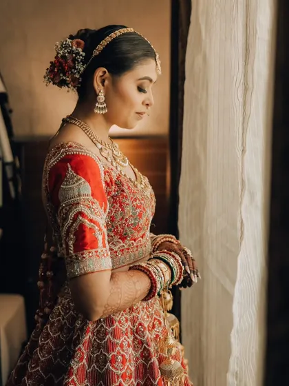 A quiet, contemplative bridal portrait by the window. The soft natural light creates a serene and beautiful mood.