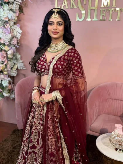 A complete bridal look with soft, glamorous waves and a statement 'Maang Tikka'. This style is perfect for a North Indian wedding ceremony or reception, offering a look that is both regal and modern.