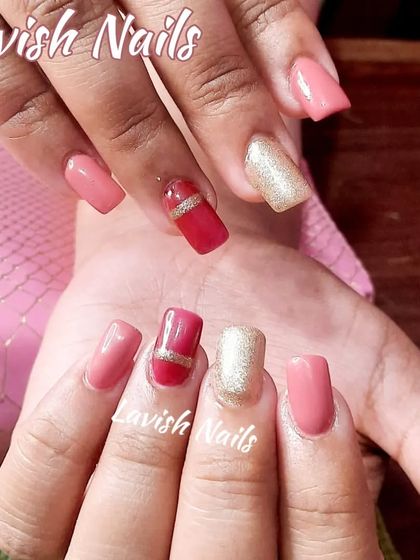 A cute, multi-colored set in shades of pink and red, with a gold glitter accent nail and gold stripe details.