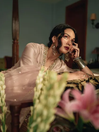 A beautifully composed shot for AR by Rhea Kapoor, with flowers in the foreground. This technique adds depth and a touch of romance to the elegant fashion portrait.