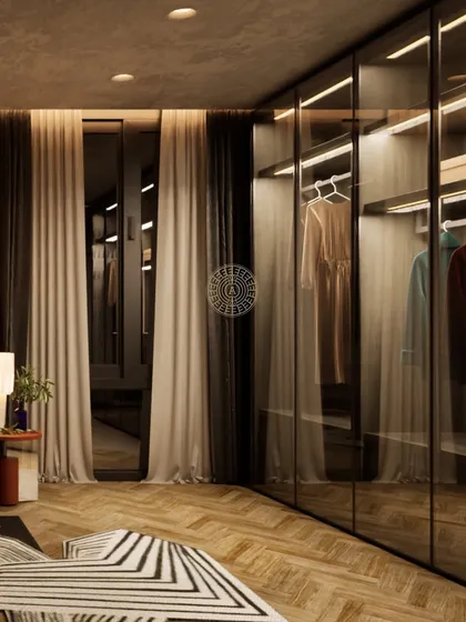 A render showing glass-fronted wardrobes with internal lighting, allowing for an organized and beautiful display of clothing. The warm wood flooring adds a cozy touch.