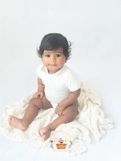 A duplicate of image 3, a perfect example of a classic sitter portrait. The clean white background and simple outfit let the baby's natural cuteness be the star.