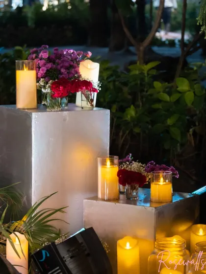 We use candles and floral arrangements on modern silver pedestals to create elegant decor points throughout the venue, adding warmth and sophistication.