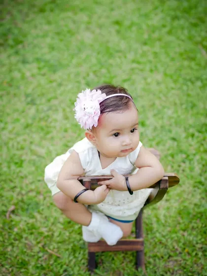A sweet baby girl sitting on a small chair in a garden. Simple outdoor portraits can be so beautiful and timeless.