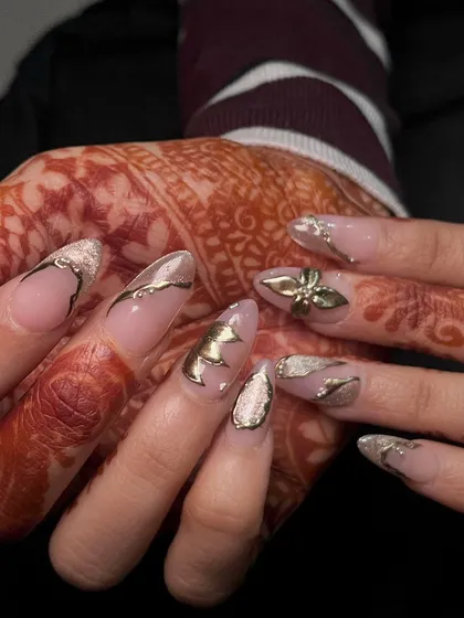 Another view of these luxurious gold bridal nails, showing how the metallic elements catch the light. This is a look fit for a queen.