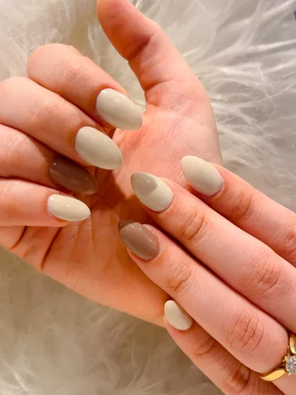 Another angle of this chic, coffee-inspired manicure. The almond-shaped nails are painted in coordinating neutral shades for a sophisticated and modern look.