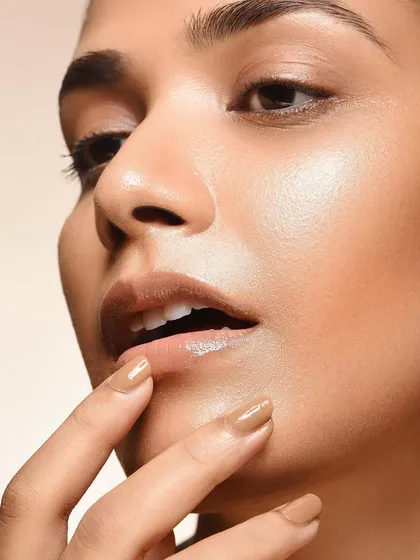 Detail shots are crucial in beauty photography. This image focuses on the lips and nails, showcasing a natural, glossy look. The careful lighting and composition make it a strong shot for cosmetic or skincare brands.