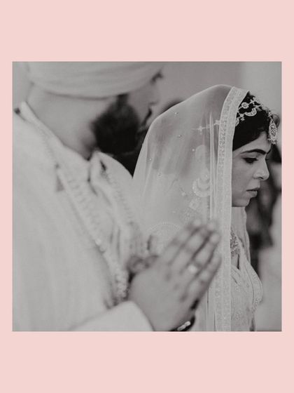 A black and white portrait of Kajal in a moment of quiet prayer, her face reflecting the solemnity and beauty of the ceremony.