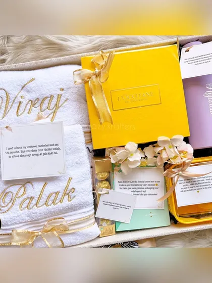 The final curated hamper for Viraj and Palak. It includes personalized towels, a 'Hydrate' bottle, L'Occitane skincare, and other fun items to celebrate them.