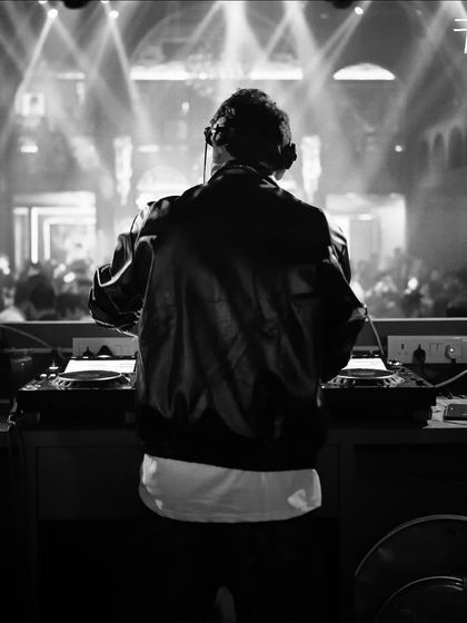 A black and white shot from behind the console at Hashtag in Kolkata. It captures the classic DJ moment, focused on the music and the crowd.