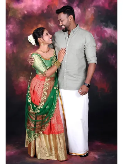 A studio couple portrait featuring traditional South Indian attire. I use professional lighting to bring out the rich colors and details of the outfits against a classic painted background.