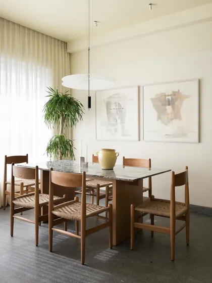 This dining space is centered around a custom oak table with intersecting surfaces and woven-seat chairs I designed. I believe a dining table is a place for connection, so I focus on creating pieces that are both beautiful and built to host a lifetime of memories.