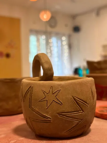 A star-engraved mug, unglazed and full of potential. The simple design is very effective.