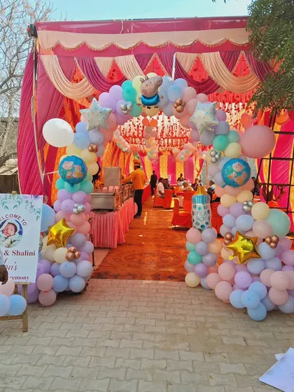 For outdoor events in tents or marquees, I create welcoming entrances that set the tone for the party. This large balloon arch uses a soft pastel color palette with star and character foil balloons to match the baby shower theme.