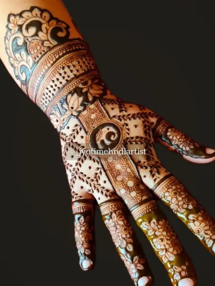 A detailed back-of-hand design featuring a baby elephant motif at the center. The pattern is filled with fine lines, dots, and floral elements, extending up the wrist.