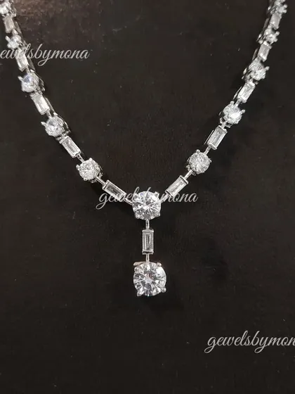 A detailed look at the pendant drop of the diamond tennis necklace. The combination of round and baguette diamonds creates a beautiful texture and maximizes the brilliance of the piece.