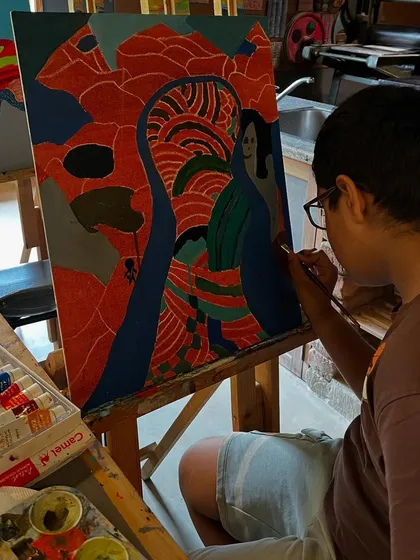 A young artist concentrates on the intricate patterns in his David Hockney inspired landscape. We encourage students to observe details and develop their own unique style.
