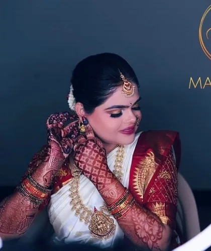 A classic South Indian muhurtham look, featuring a flawless base that glows under the lights, intricately defined eyes, and traditional temple jewellery. This look is all about timeless elegance.