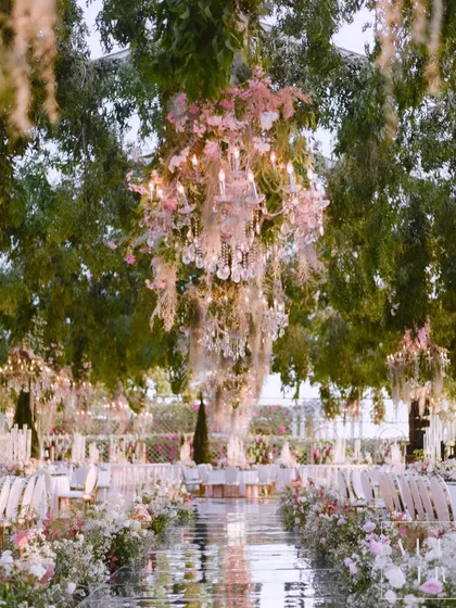 For the reception dinner in Bali, I created an enchanted English garden under the trees. A mirrored walkway reflected the hanging floral chandeliers, creating a magical path through the long, elegantly set dining tables.