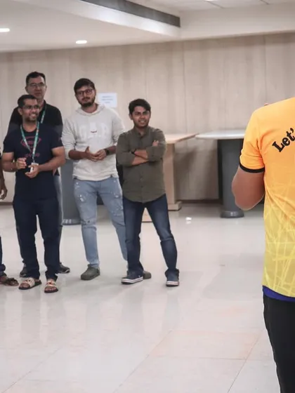 A group of employees listening intently during a corporate team building event. Our coaches ensure everyone feels comfortable and ready to participate in the upcoming fitness challenges.