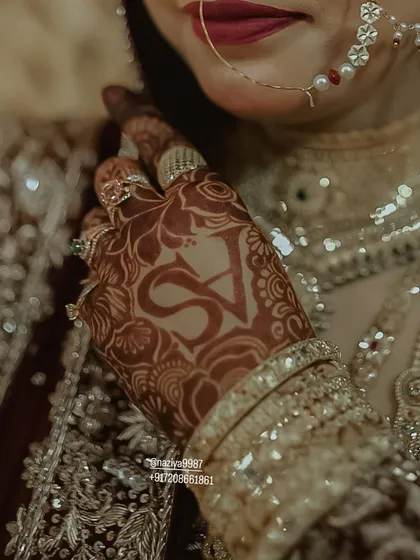 Your mehendi should tell your story. Here, I've woven the couple's initials 'S' and 'V' into the intricate bridal design. It's a special touch that makes your henna uniquely yours.