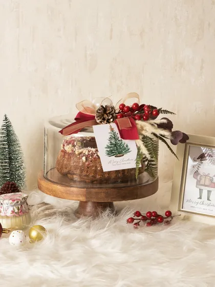 A beautifully styled shot of my Christmas plum cake, showing how it can be the centerpiece of a festive arrangement.
