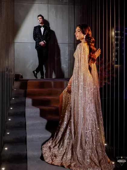 A high-fashion style portrait of the couple on a staircase, the composition and lighting creating a dramatic and elegant look.