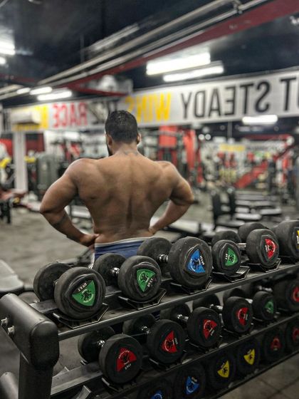 A back pose in front of the dumbbell rack. This is where the work is done.