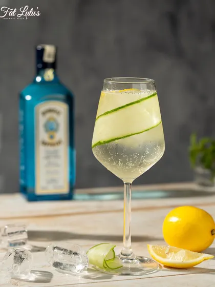 A refreshing gin and tonic, garnished with a ribbon of cucumber and a slice of lemon. It’s a clean, crisp classic that’s perfect for any time of day.