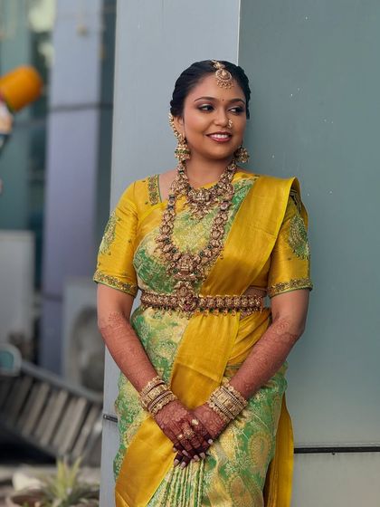 A poised and elegant shot of Prithivi. Her makeup enhances her features, giving her a regal and timeless bridal appearance.