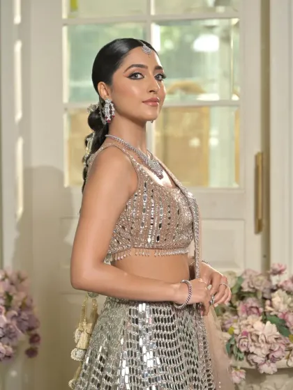 A portrait shot where the sleekness of the hair from the front is evident. This clean styling ensures the focus remains on the model's face and the statement jewellery.