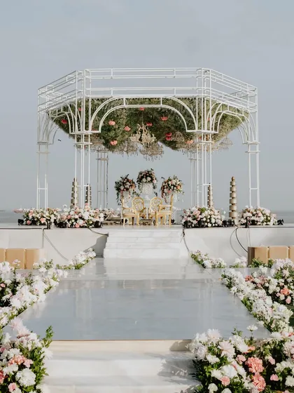 The complete mandap setup with its mirrored aisle, creating a perfect reflection that enhances the structure's beauty and the surrounding floral decor.