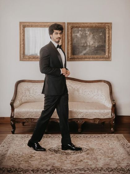 A classic portrait of the groom, looking dapper in his tuxedo. The vintage-inspired setting adds a touch of old-world charm.