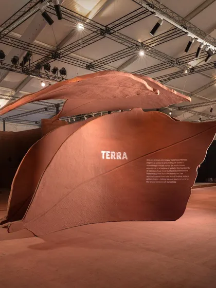 The 'TERRA' text is projected onto one of the giant leaf sculptures, grounding the abstract form in its conceptual origin. This piece was our interpretation of the Colour of the Year.