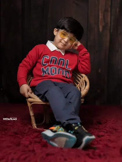 We offer a variety of looks within a single session. This relaxed pose shows a different side of our 'Cool Kid' theme, capturing a casual and confident vibe.