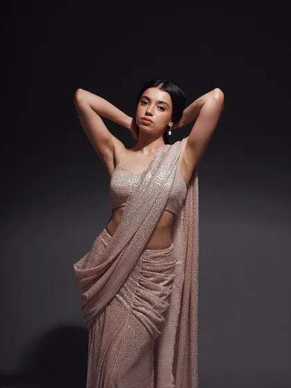 An elegant and statuesque pose. The clean lines and the model's posture emphasize the modern drape of the saree, creating a sophisticated and timeless image.
