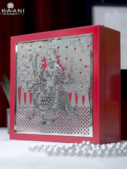 This vibrant red gift box is adorned with a powerful silver-plated image of Goddess Durga. It is a luxurious and auspicious choice for festive or wedding gifting.