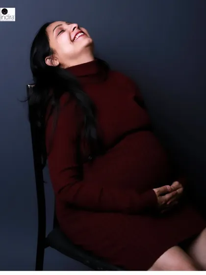 A moment of pure, uninhibited laughter from the mother-to-be, capturing the true joy of her pregnancy journey.
