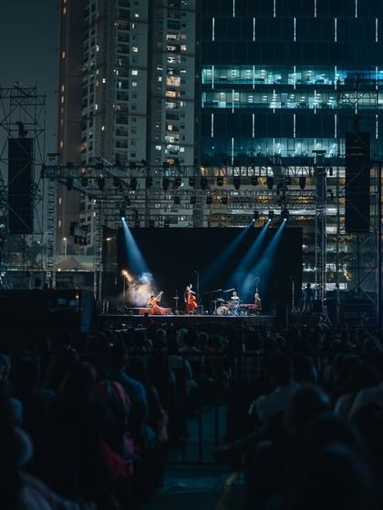 The Anoushka Shankar concert experience in an urban setting, with the stage framed by city lights.