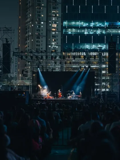 The Anoushka Shankar concert experience in an urban setting, with the stage framed by city lights.