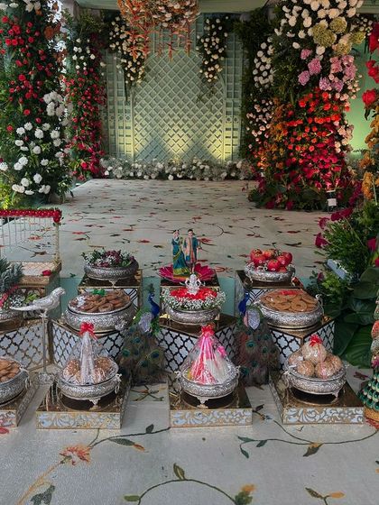 A view of the offering table set before the dense, multi-colored floral stage.