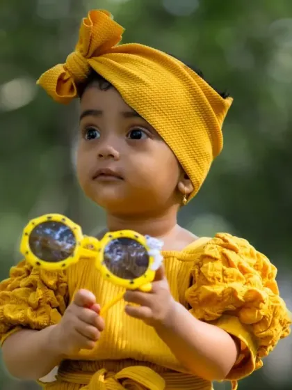A beautiful, thoughtful portrait of a little girl outdoors. The soft, blurred background keeps the focus entirely on her.