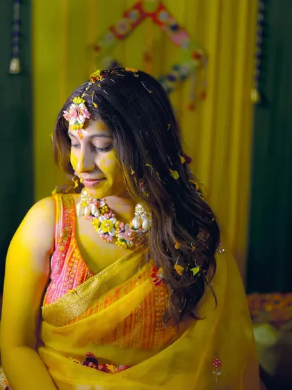 A quiet, contemplative moment during the Haldi ceremony, with the bride adorned in floral jewelry.