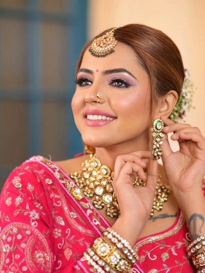 A complete bridal look featuring a heavy, gold-plated Kundan necklace, haath phool, and maang tikka, all available for rent.
